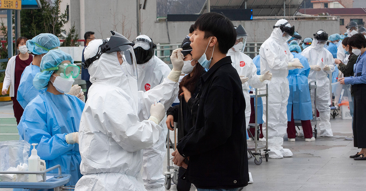 身穿防护服的韩国医护人员，在京畿道议政府市的圣玛丽医院为民众进行新冠病毒检测。（档案照）