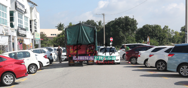 狭窄的道路遭轿车违规停泊，导致罗厘无法川行，加剧公路问题。