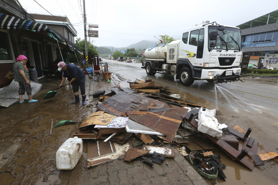 洪水退去后，韩国铁原市的居民回家展开清理工作。（美联社）