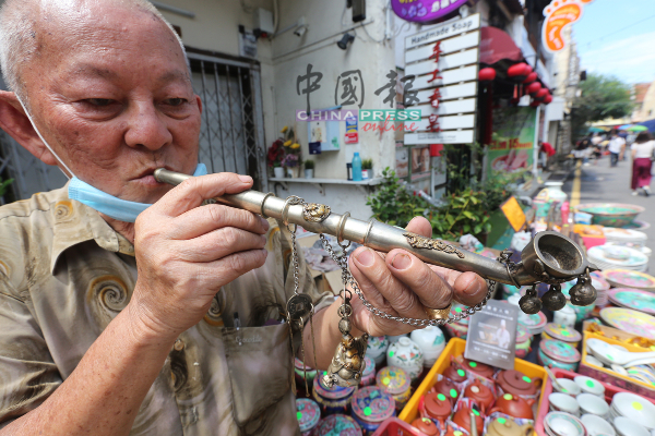 来自麻坡的业者，向中国报记者展示极具中华特色的烟斗。