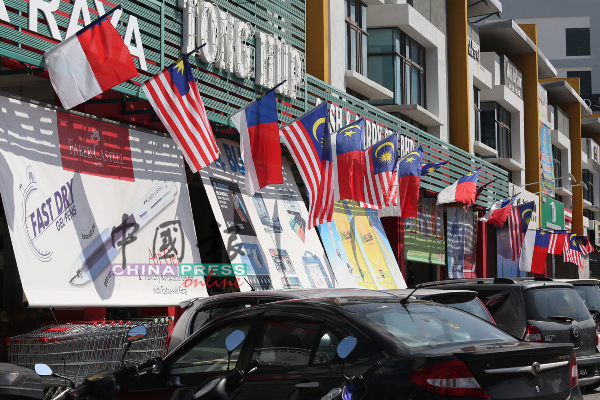 甲市区商店也挂国旗庆祝国庆日的来临。