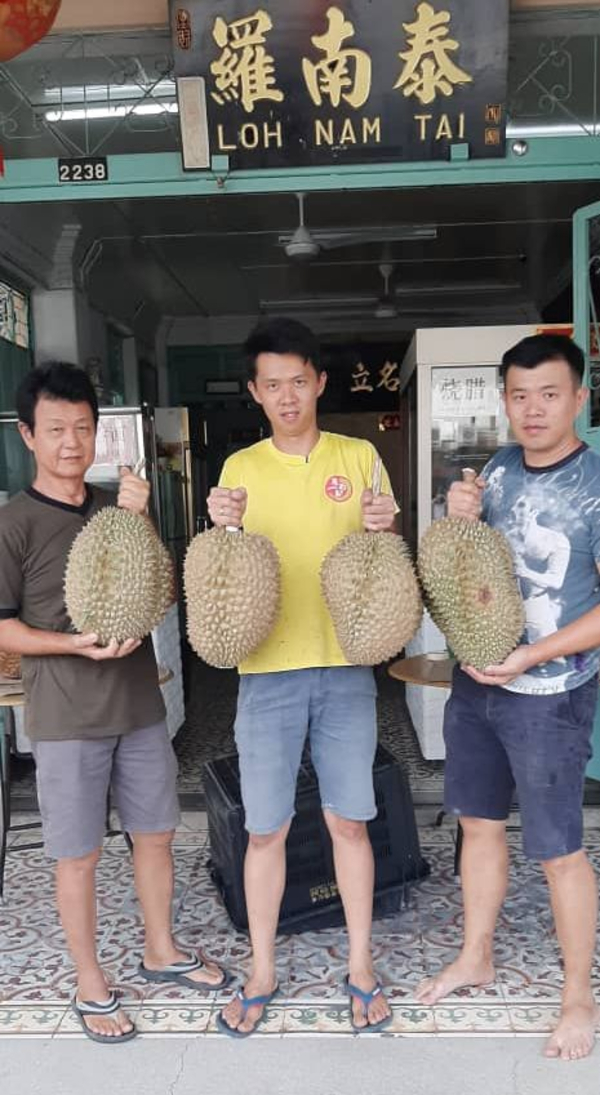 罗家俊（中）与父亲罗汉璋（左）及弟弟罗家笙，展示超过8公斤重的大榴梿。