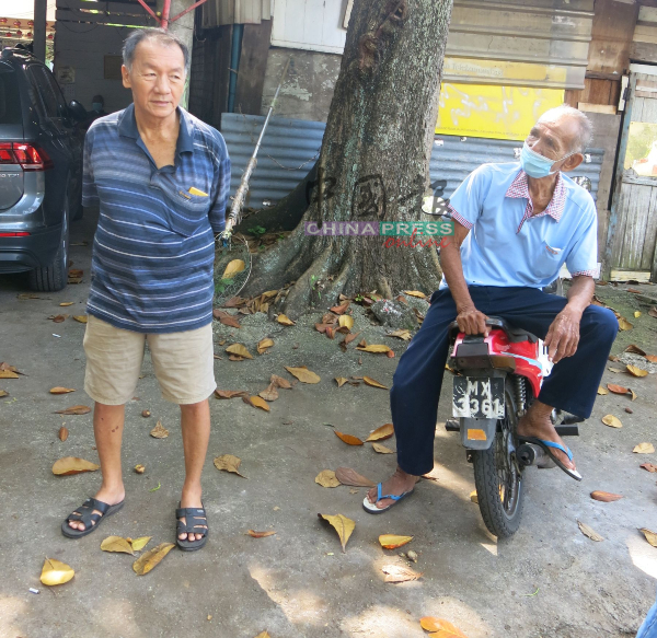 范焕祥（左）说，在甘榜爪哇的海南村已经走入历史，右为村民梁亚烈。