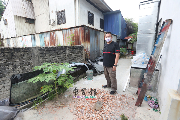 刘政荣向记者展示2个月前设置在后巷的储仓室被拆走，行径夸张。