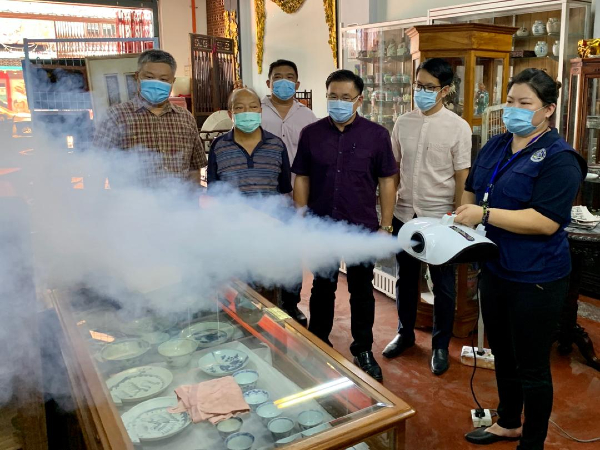 蔡永泉（左起）、刘柏祥、颜天禄及陈炜建，向义工了解消毒喷雾的操作程序。