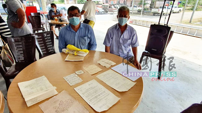 2名榴梿农董金土（右）和梁金明（左）展示当年向政府申请地契的文件。