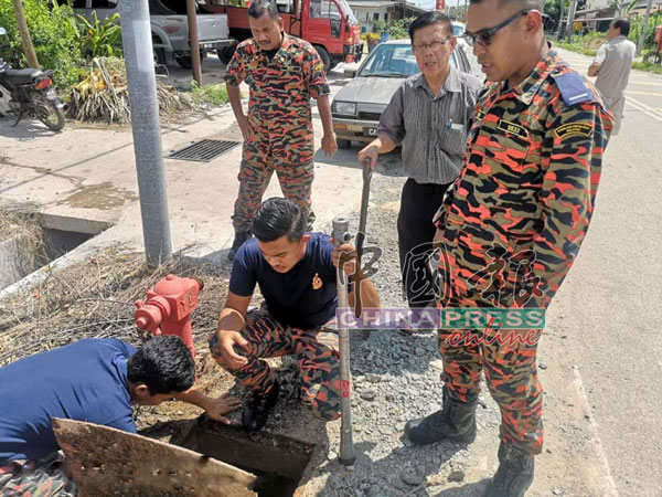 榕吉村的消防栓被发现出现问题，潘宥磬（右2）随同消防员巡视情况。