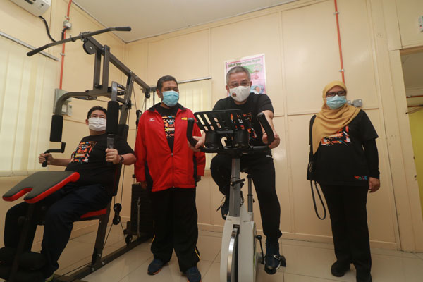 沙菲克（左）和阿汉峇峇（右2）试用保健中心内的健身器材。