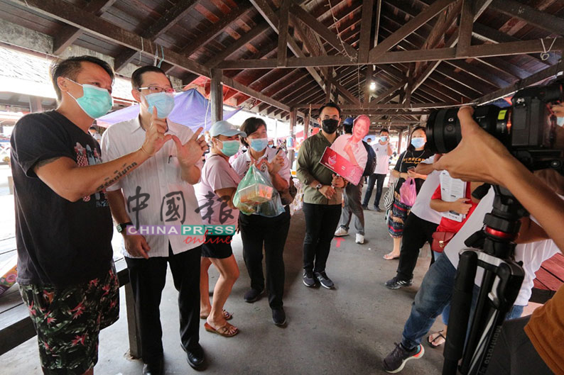 林冠英（左2）、珍妮（左4起）及大山脚国会议员沈志强在东贡岸斗磨拜票时，与民众一同比出“民兴党+”的手势。