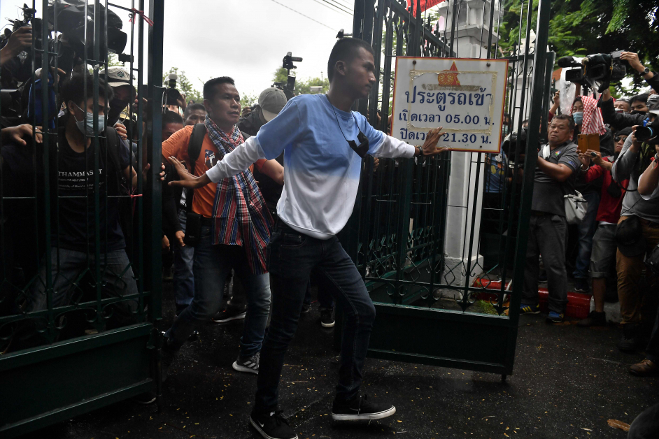 “法政与游行联合阵线”领袖之一帕努蓬（中）强行打开法政大学校铁门，引领示威者进入校园集会。（法新社）