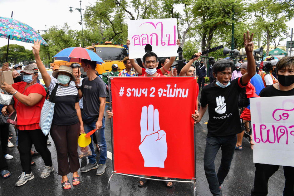 示威者拿着三指手势横幅，在曼谷集会。三指手势代表反独裁。（法新社）