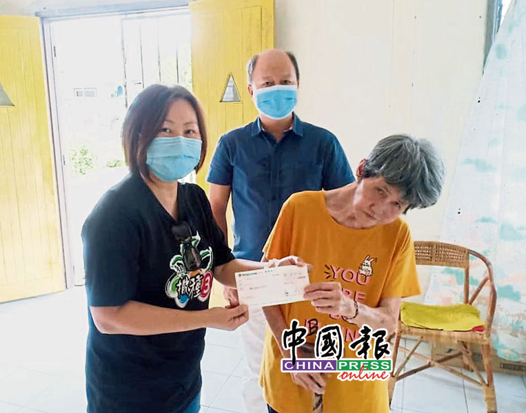 《中国报》记者赵诗绮（左）移交支票给温莲好，由谢保恒（中）见证。