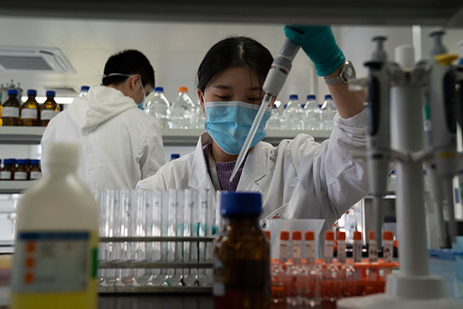 中国科兴控股生物技术有限公司研究员周四在北京工厂生产CoronaVac疫苗。（美联社）