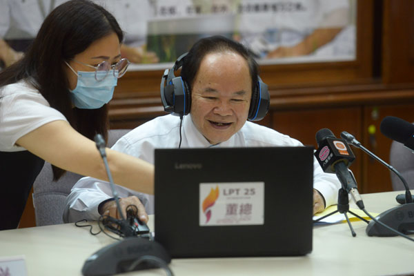 陈大锦（右）在教职员的指导下，学习使用“董总E启学”线上学习平台。