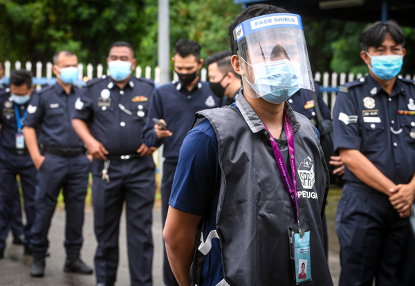 监督投票过程的选委会职员戴上口罩及面罩，做足防范措施。