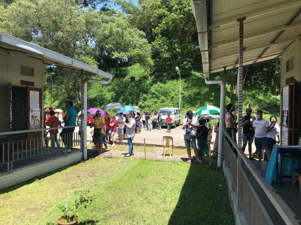 佳雅师范学院投票中心的选民在太阳底下排队等候投票。