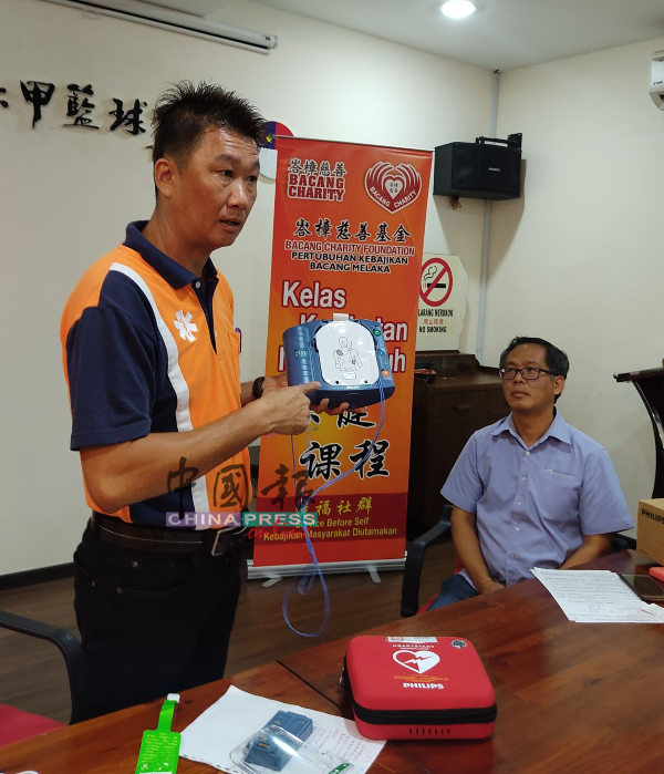 峇樟救伤队主任萧卓勋（左）讲解使用自动体外心脏除颤器的方式，右为刘志良。