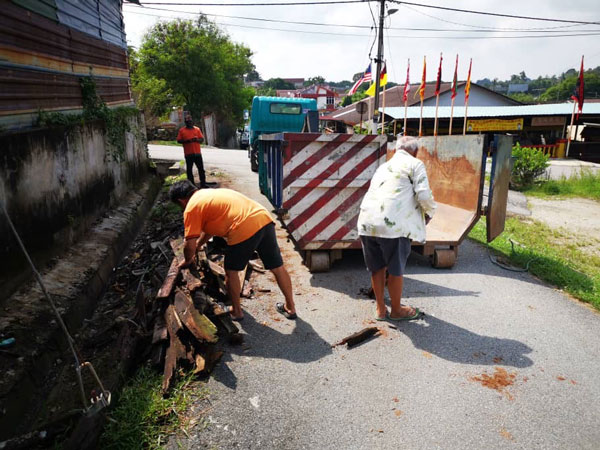 亚沙新村村委同心协力，把已腐烂的木条清理干净。