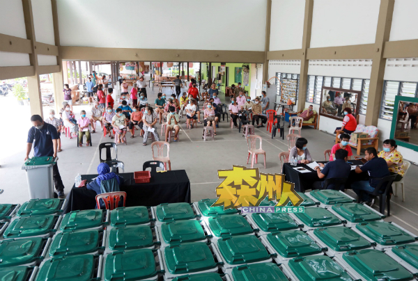 村民聚集民众会堂,等待更换新垃圾桶。