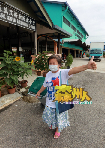 成功换得垃圾桶的村民,高兴地举起拇指赞扬。