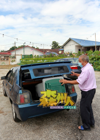 村民将新垃圾桶放在后车厢,运载回家。