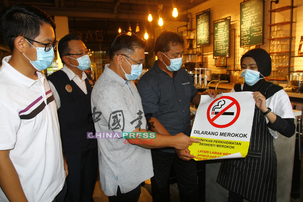 陈炜建（左起）鲁斯迪、颜天禄及拉末马里曼确保商店贴上禁烟贴纸。