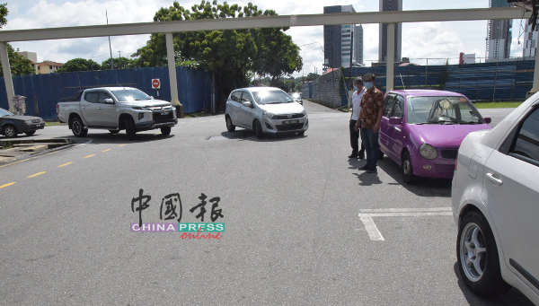 刘志良（右起）及陈劲源站在路口处，看着车辆转右时险些撞及，岌岌可危。