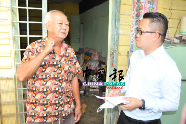 廖启致(左)向何永铧示范匪徒如何将巴冷刀架在他脖子上,威胁他交出财物。