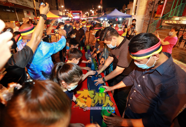 朱建华(右2)与民众一起玩叠杯竞技游戏。