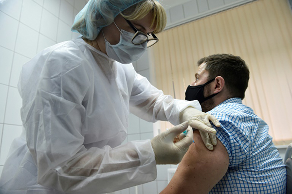 俄罗斯医护人员为志愿者注射“卫星-V”疫苗。