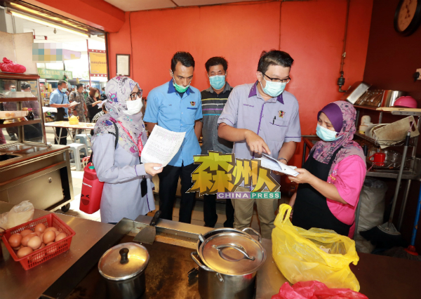 李汉强(右2)与官员一起派通知信,提醒租户交租。