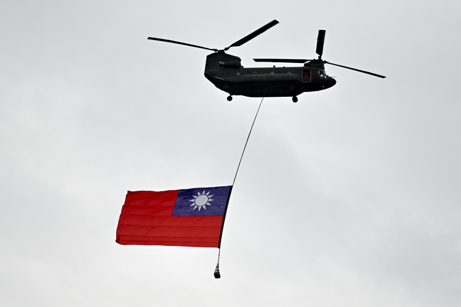 在台湾庆典期间，一架军用直升机在台湾总统府前飘扬着台湾国旗。