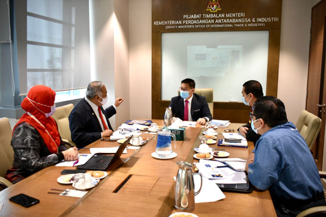 大马生产力机构总监拿督阿都拉迪夫（左2）向林万锋（中）介绍MyMudah及该机构的其他举措。