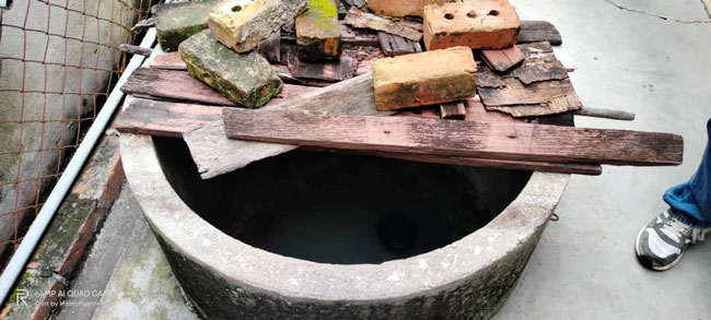 井口仅用简单木板和砖头压住。