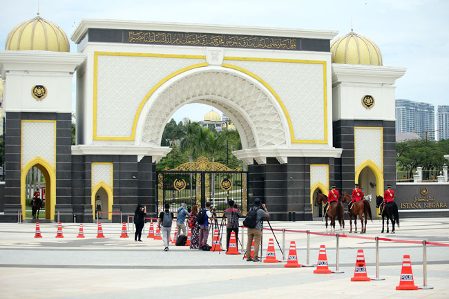 警方在国家王宫门口安置隔离锥，确保媒体保持人身距离。