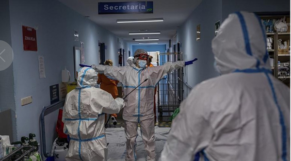 马德里一家医院的医护人员离开冠病病房前全身消毒。