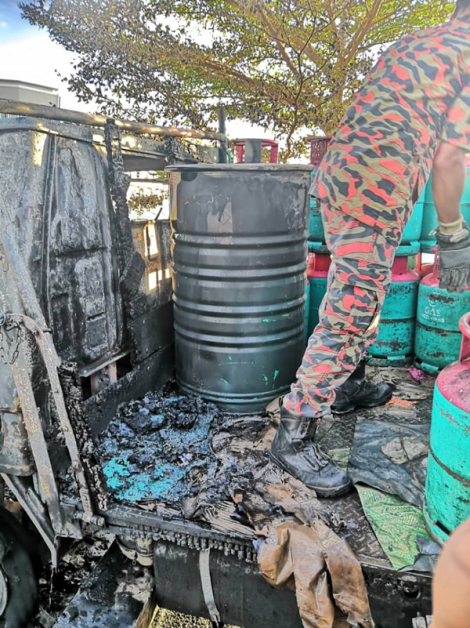 火势熄灭后，消拯员检查罗厘上的液化石油气桶。