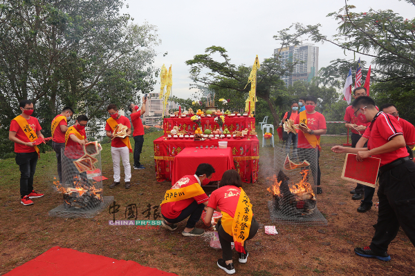工作人员在祭祀仪式上焚化金纸。