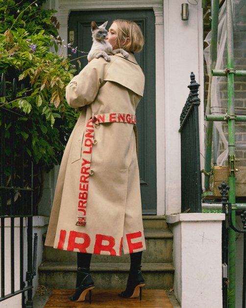 Burberry配件设计师Sabrina穿2021早春Logo风衣在位于Notting Hill自家门口拍型录，不忘偷渡爱猫。