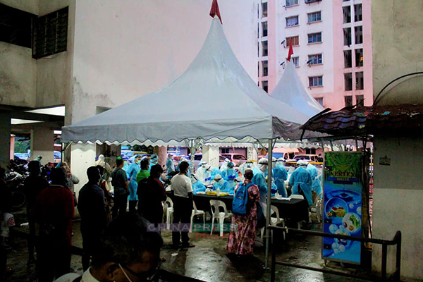 卫生部官员在组屋外搭建帐篷，为每名住户进行登记和检测程序。