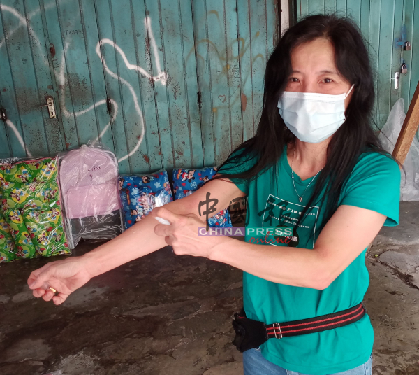 吴丽玲在店内不时在手脚喷射防蚊雾，避免被蚊子叮咬。
