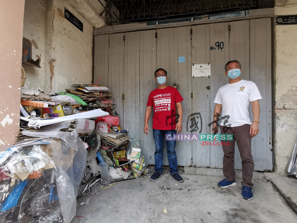 邱培栋（右）和刘志俍巡视世遗老街区时，看见一空置单位外堆满杂物。