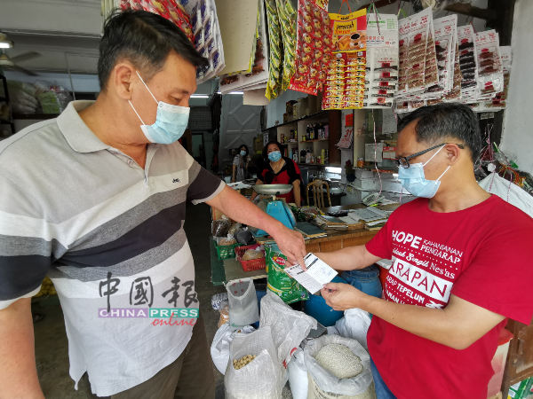 市民（左）向刘志俍展示其骨痛热症验血纪录。