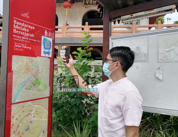陈炜健扫描资讯牌上的二维码，进入“Ceritera Melaka”平台。