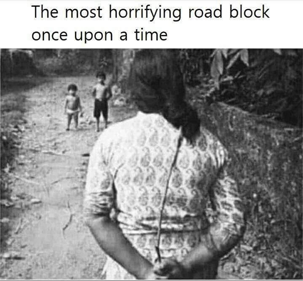 一名母亲拿着藤鞭，站在路口等着教训偷跑去玩耍的孩子。