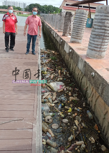 河岸码头处堆积大量垃圾，让刘志良（右）看了摇头，左为陈劲源。