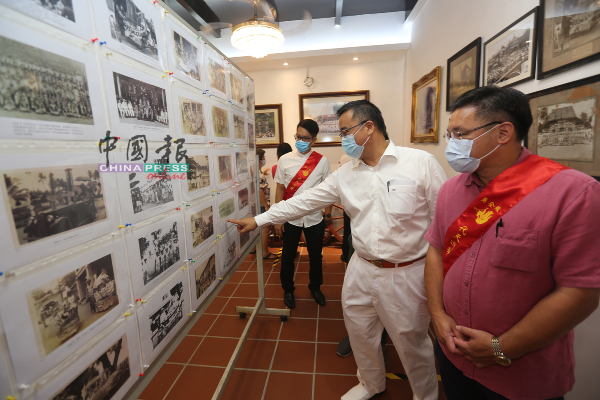 颜天禄（右起）及颜泳和参观展示在“马六甲送王舡博物馆”内的各源流新闻报导。