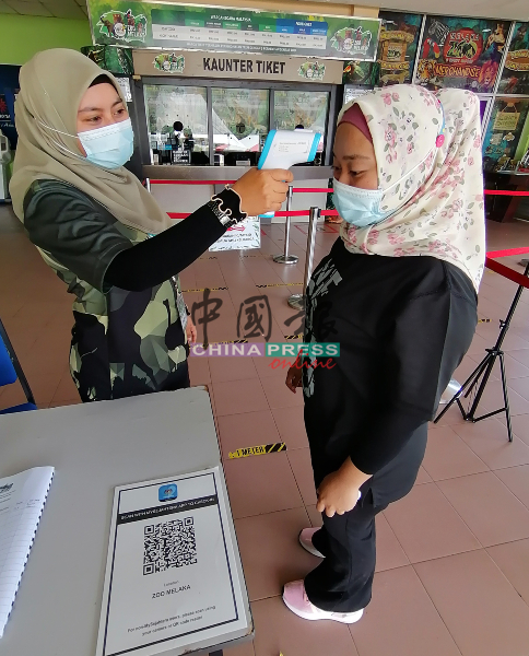 马六甲动物园工作人员向每个到访者测体温。