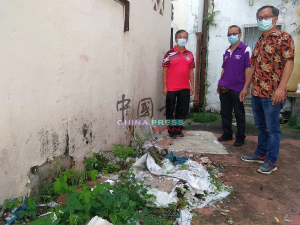 陈劲源（左起）、李祥生和刘誌俍，勘察扔在后巷的建筑废料。