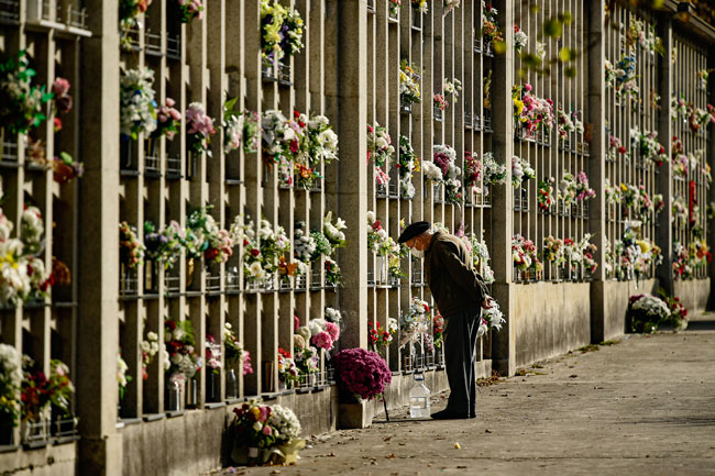 西班牙潘普洛纳一名男子周日在坟场拜祭亲友。